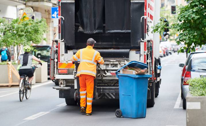 garbage,and,waste,removal,services.,worker,loading,waste,bin,into